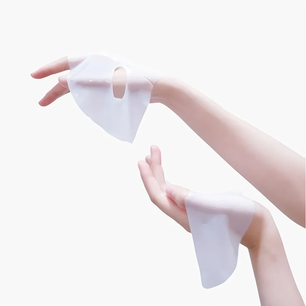 Primer plano de la textura suave y flexible de la mascarilla de hidrogel Kara Face Mask sostenida en las manos