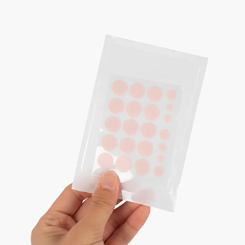 Mano sosteniendo el empaque de Kara Pimple Patch, mostrando la lámina con los parches hidrocoloides en forma de círculos